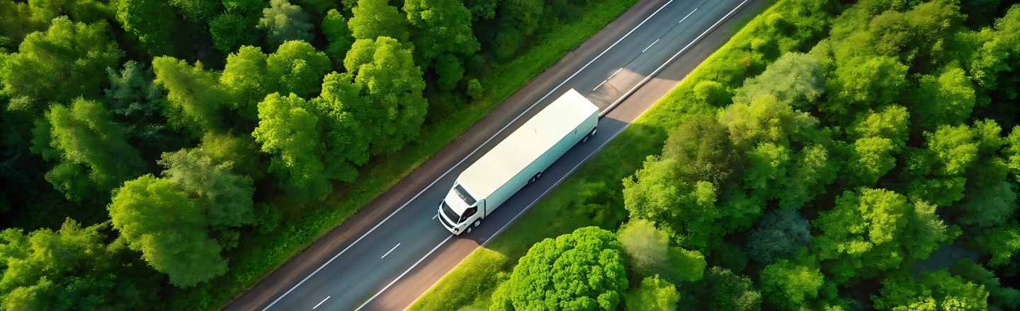 Vogelperspektive auf einen LKW auf einer Straße, als Symboldbild für Nachhaltigkeit in der Logistik